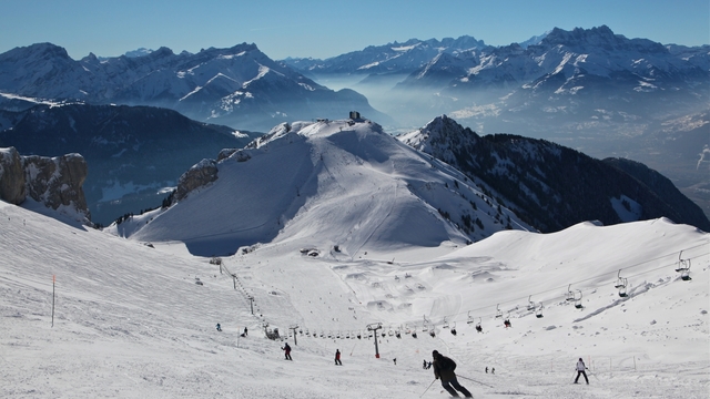 Des skieurs descendent la piste Chaux de Mont avec vue sur la Berneuse et panorama dents du midi.